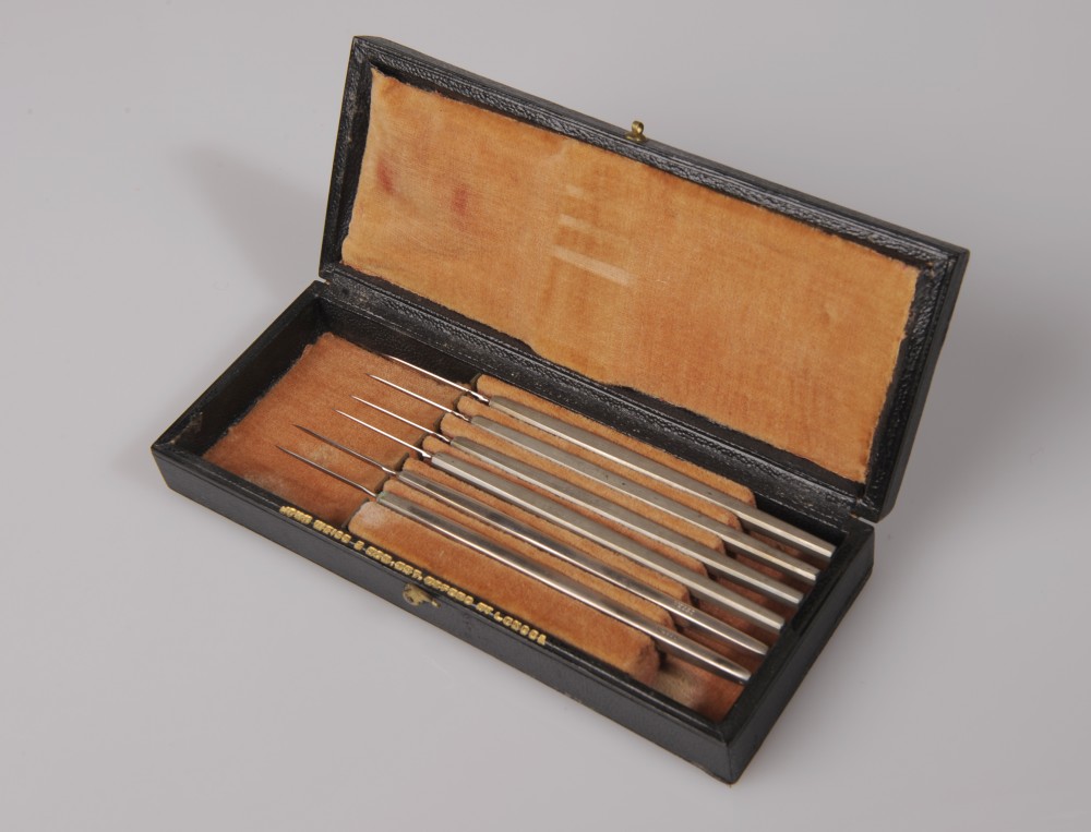 Boîte bois, gainée de simili cuir noir avec instruments chirurgicaux